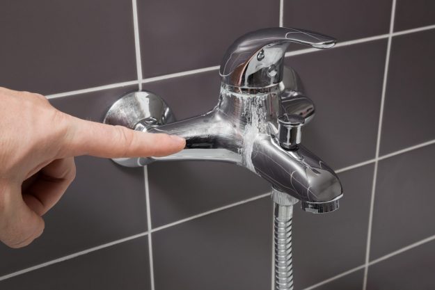 Man’s,Hand,Finger,Pointing,To,Calcified,Water,Tap,In,The Mixer Shower or Electric Shower