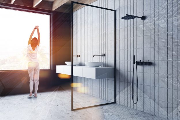 Young,Woman,In,Pajamas,Standing,In,Sunlit,Bathroom,With,Tiled luxurious bathroom experience